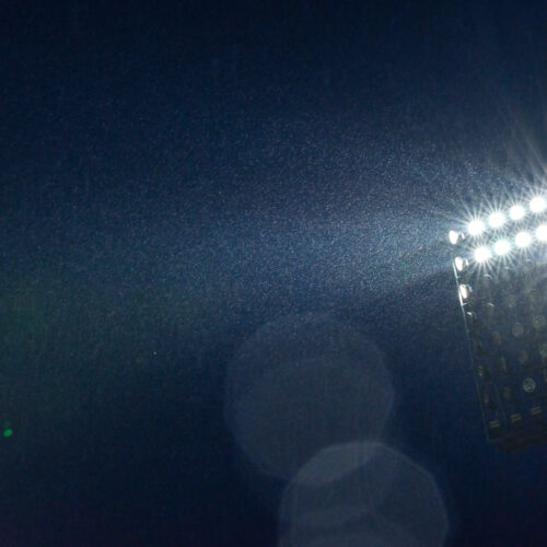 Partly,Lit,Floodlighting,Shining,Beams,Of,Light,Through,The,Rain,